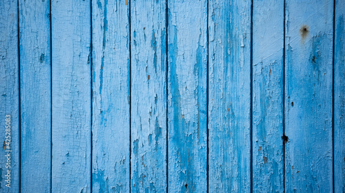 Aged blue planks with peeled paint. Blue background. Close-up. Copy space. Defocus.
