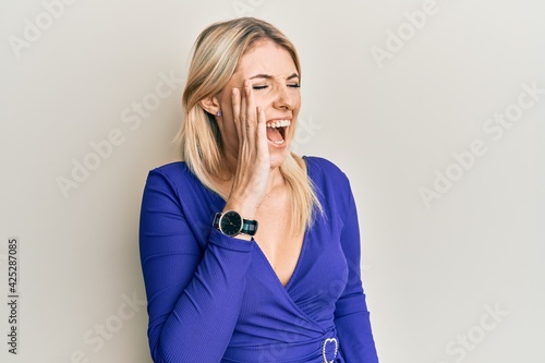 Young caucasian woman wearing casual clothes shouting and screaming loud to side with hand on mouth. communication concept.