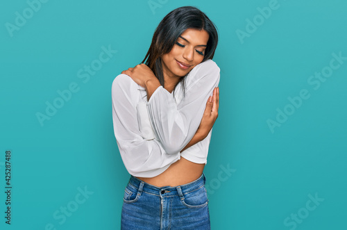 Young latin transsexual transgender woman wearing casual clothes hugging oneself happy and positive, smiling confident. self love and self care
