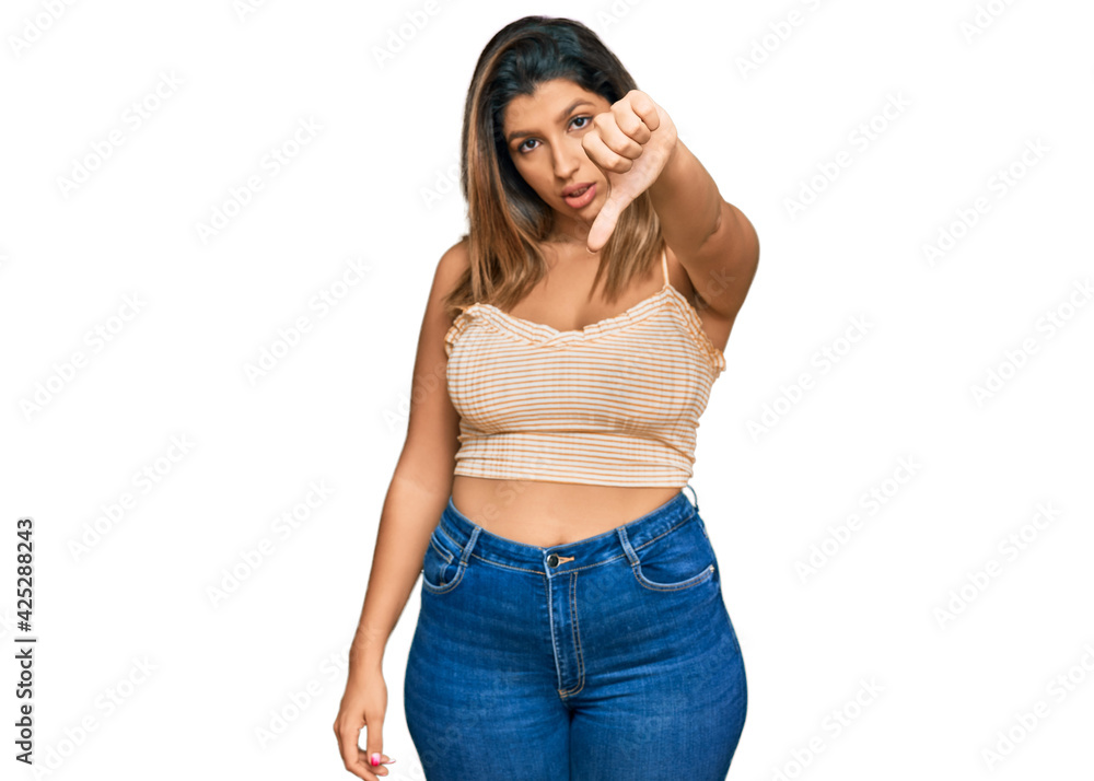 Beautiful brunette woman wearing casual clothes looking unhappy and angry showing rejection and negative with thumbs down gesture. bad expression.