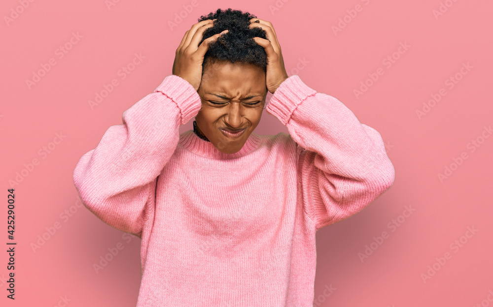 Young african american woman wearing casual clothes suffering from headache desperate and stressed because pain and migraine. hands on head. Young african american woman wearing casual clothes suffering from headache desperate and stressed because pain and migraine. hands on head.
