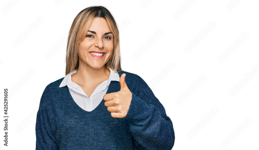 Young caucasian woman wearing casual clothes doing happy thumbs up gesture with hand. approving expression looking at the camera showing success. Young caucasian woman wearing casual clothes doing happy thumbs up gesture with hand. approving expression looking at the camera showing success.