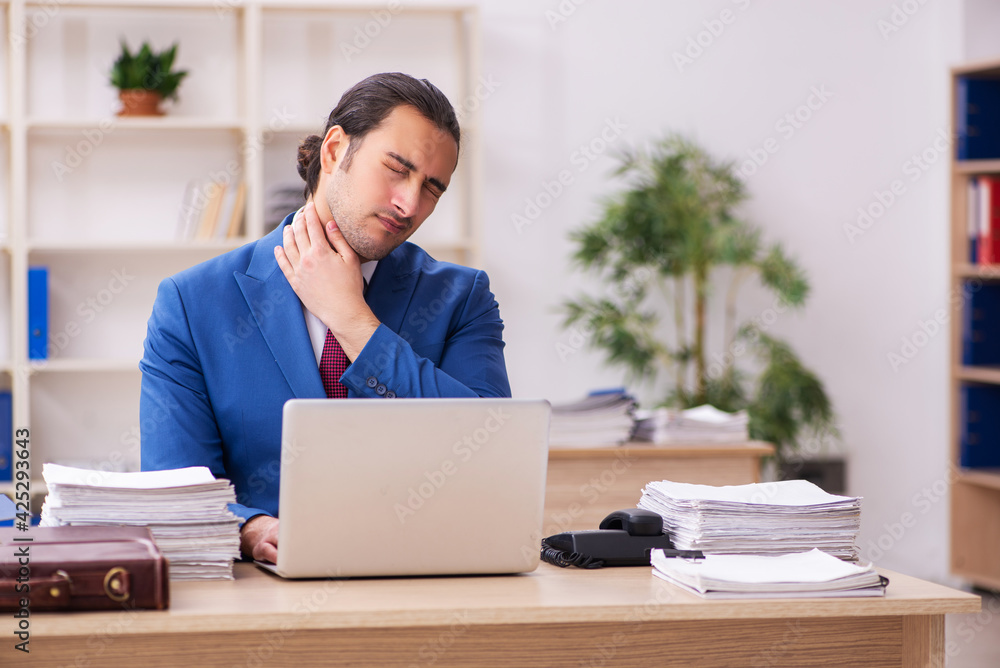 Extremely tired young male employee in the office Extremely tired young male employee in the office