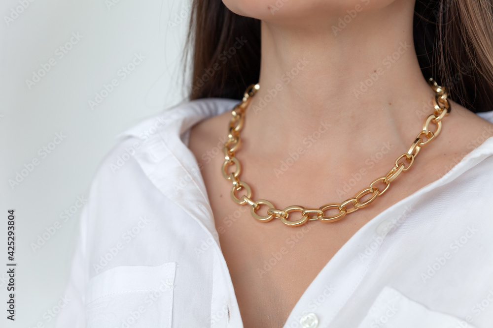 Beautiful model brunette in modern gold metal necklace chain Beautiful model brunette in modern gold metal necklace chain