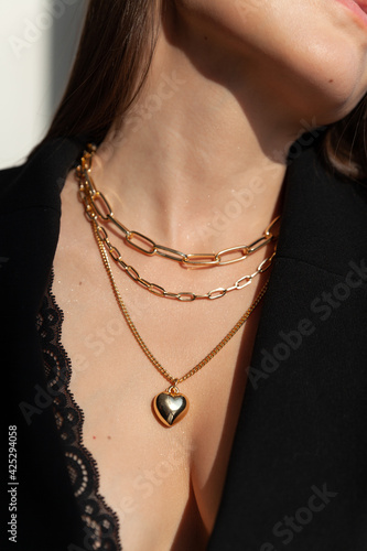 Beautiful model brunette in modern gold metal necklace chain