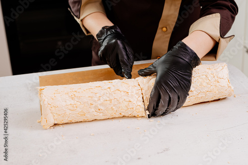 The process of making a meringue roll. The pastry chef prepares a meringue roll. Cooking meringue roll in the kitchen. Meringue roll with strawberries and grated chocolate.