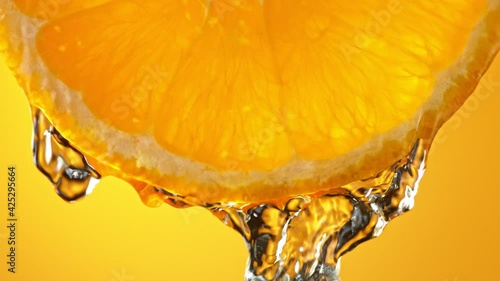 Super Slow Motion Macro Shot of Flowing Water from Fresh Orange Slice at 1000fps.