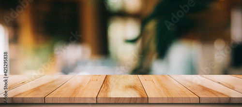 Empty wooden table top with lights bokeh on blur restaurant background.