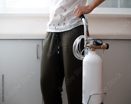 Photography Woman is holding portable oxygen gas cylinder for use at home