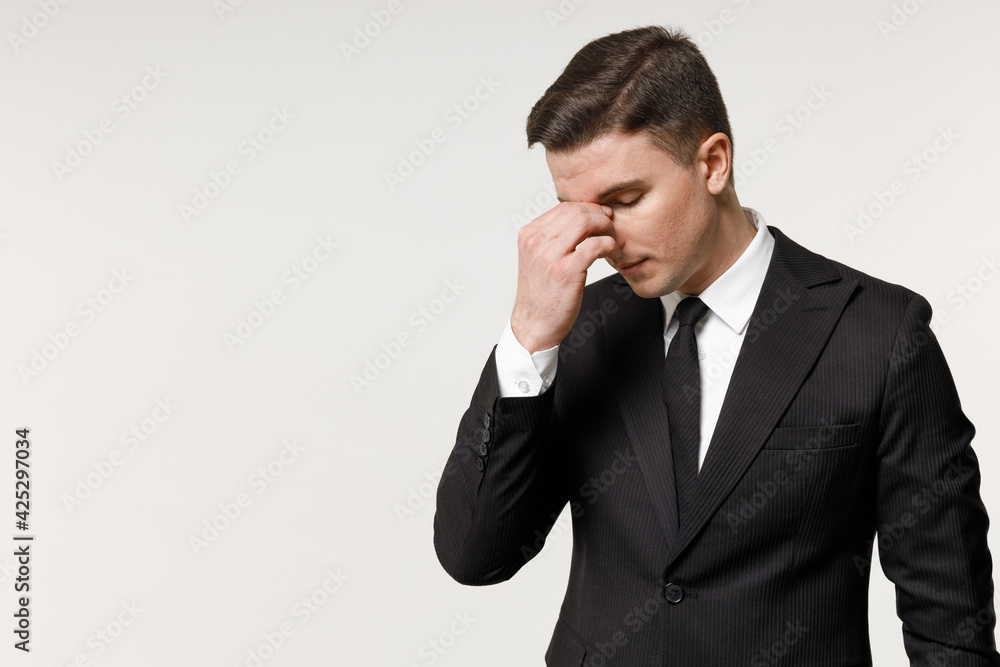 Young sick pensive employee business corporate lawyer man 20s in classic formal black grey suit shirt tie working in office put hand on nose rub pinching isolated on white background studio portrait Young sick pensive employee business corporate lawyer man 20s in classic formal black grey suit shirt tie working in office put hand on nose rub pinching isolated on white background studio portrait