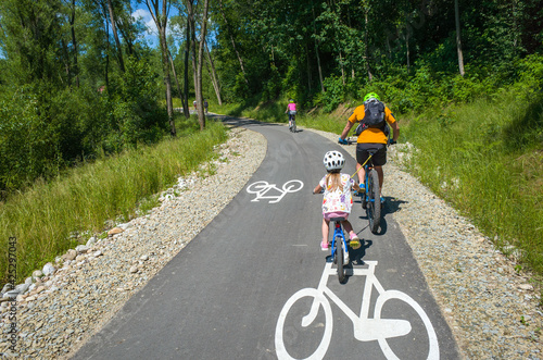 Family Cycling around Czorsztynskie lake near Niedzica village on sunny spring day, Pieniny Mountains, Poland