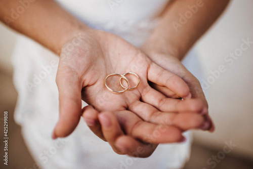 the bride holds wedding rings in her hands