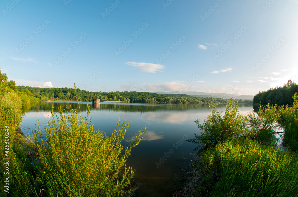 Beautiful panorama of autumn lake against the background of forest and sunny sky
