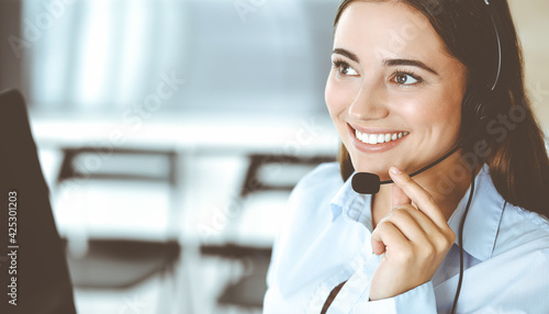 Photography Brunette female customer service representative in a headset is consulting clients online