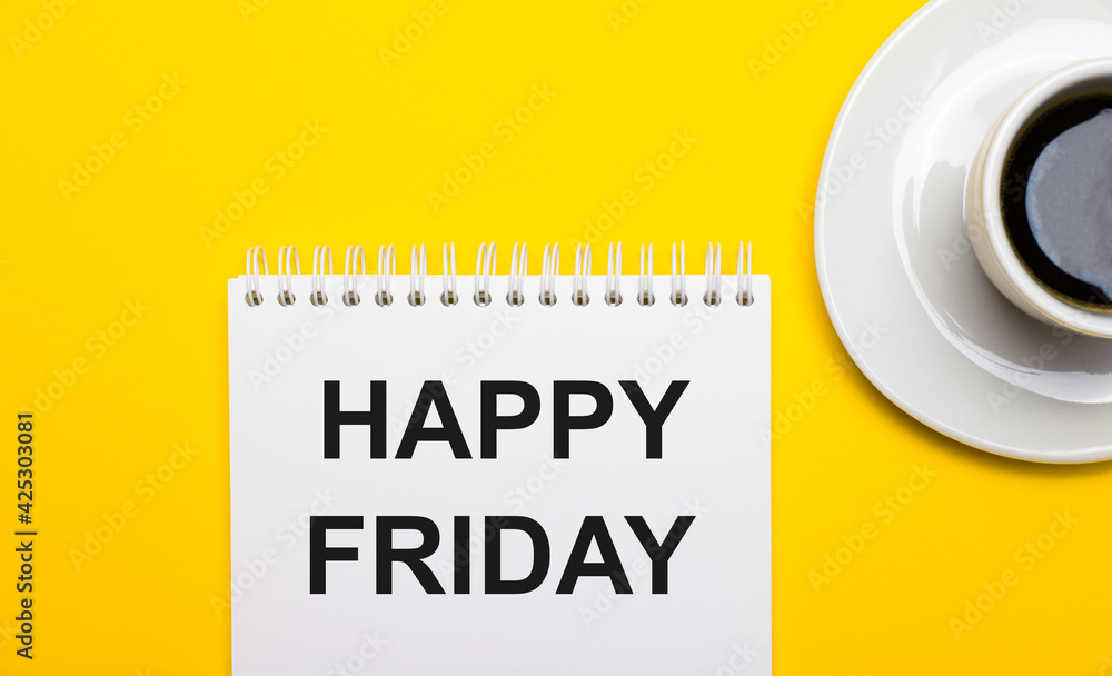 On a bright yellow background, a white cup with coffee and a white notepad with the words HAPPY FRIDAY On a bright yellow background, a white cup with coffee and a white notepad with the words HAPPY FRIDAY