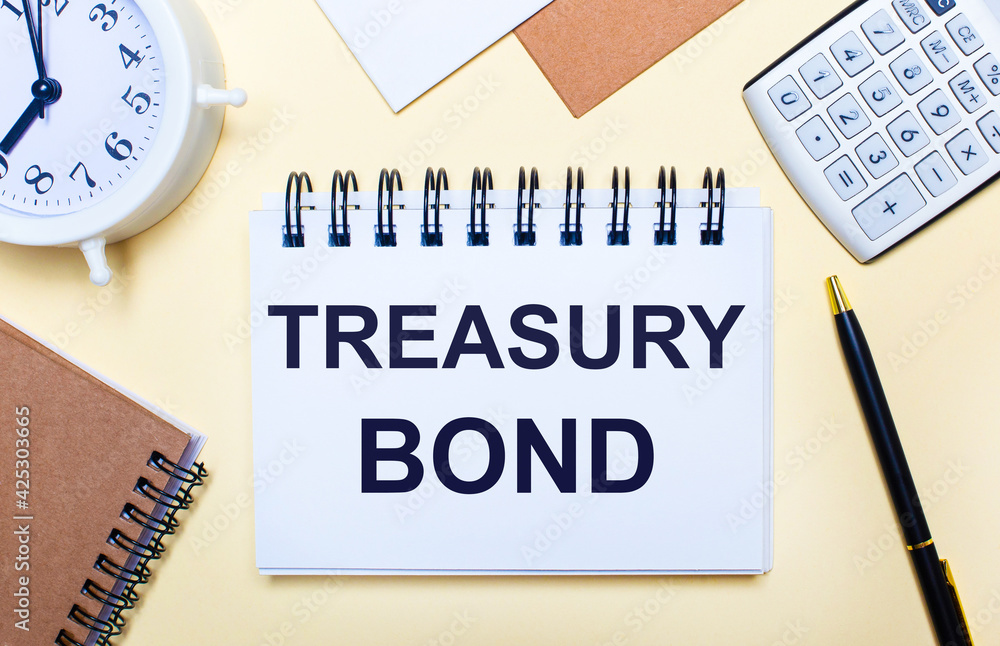 On a light background, a white alarm clock, a calculator, a pen and a notebook with the text TREASURY BOND. Flat lay On a light background, a white alarm clock, a calculator, a pen and a notebook with the text TREASURY BOND. Flat lay