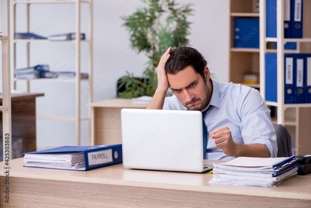 Young male bookkeeper working in the office Young male bookkeeper working in the office