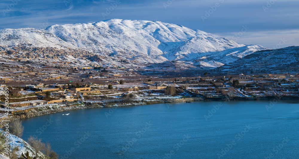 Beautiful winter morning landscape at Lake Ram or Birkat el-Ram, a crater lake (maar) in the northeastern Golan Heights, Israel, surrounded by snow-covered hills