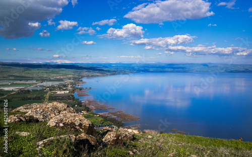 Beautiful view of the Sea of Galilee from the cliff of Mount Arbel National Park and Nature Reserve, with clouds in the sky and snow-capped Mt Hermon in the distance; Lower Galilee, Israel