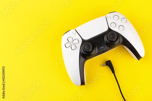 new generation of video wireless gamepad with wired charging, yellow background © Анастасия Коровина