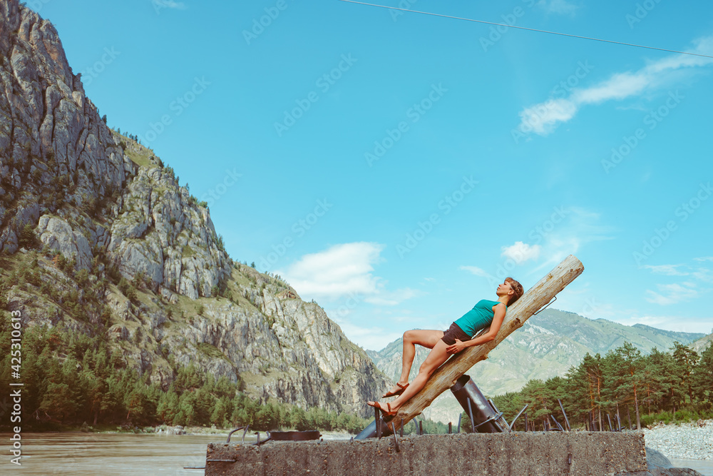 a girl poses against the background of mountains a girl poses against the background of mountains