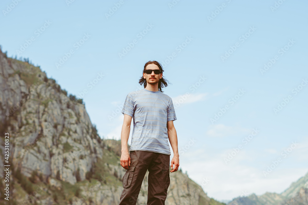 the guy stands on the background of the mountains the guy stands on the background of the mountains