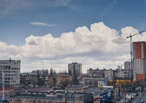 Roofs of houses and rain clouds on a blue sky. Kyiv, Ukraine.