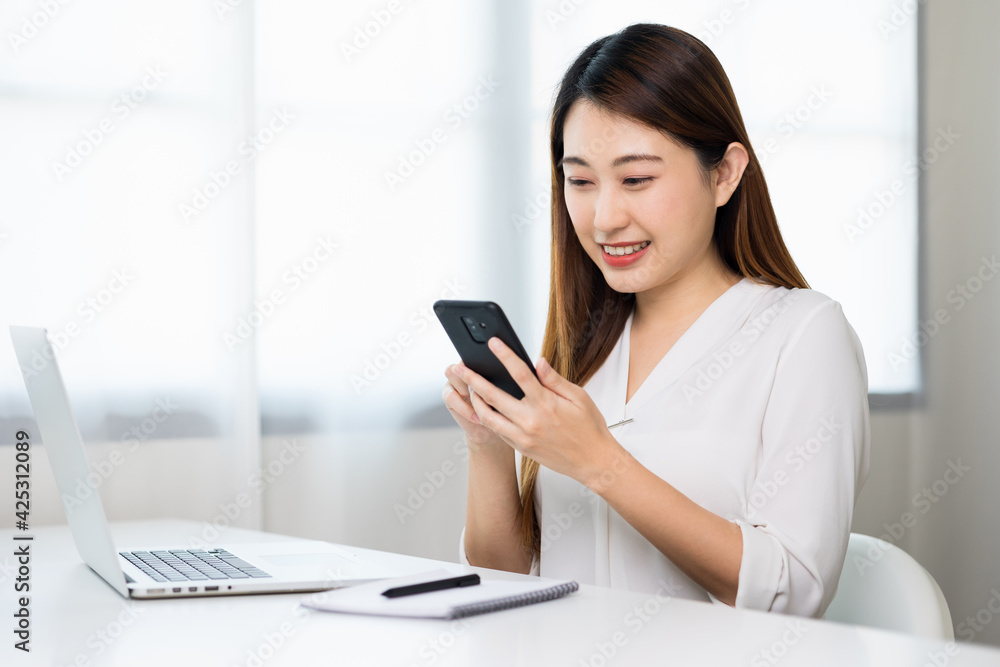Young asian beautiful business woman using smartphone. Smiling charming happy young female texting touching on display of cell phone. Young asian beautiful business woman using smartphone. Smiling charming happy young female texting touching on display of cell phone.