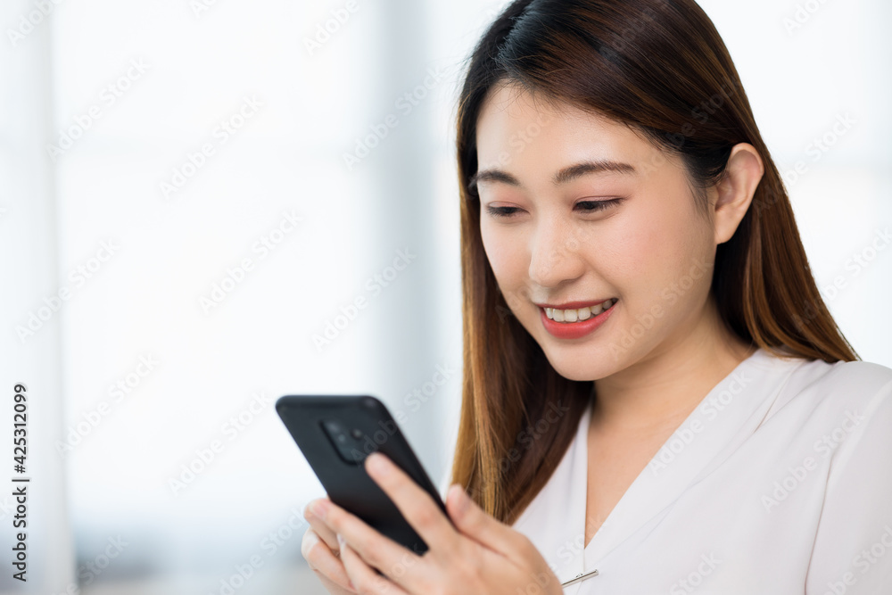 Young asian beautiful business woman using smartphone. Smiling charming happy young female texting touching on display of cell phone. Young asian beautiful business woman using smartphone. Smiling charming happy young female texting touching on display of cell phone.