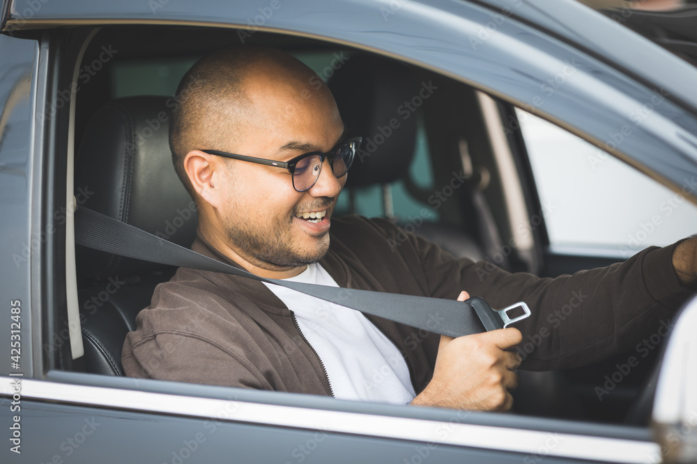 Young asian men getting new car and putting on his seat belt before driving car. Safety drive concept. Young asian men getting new car and putting on his seat belt before driving car. Safety drive concept.