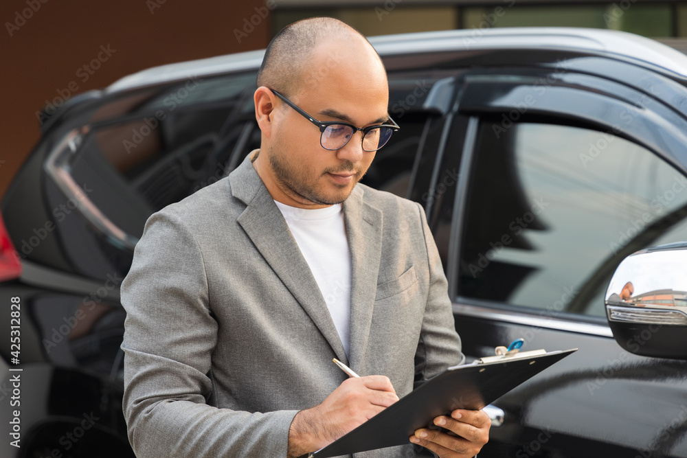 A young business man signs a luxury car leasing contract And sign a car insurance purchase contract on the documents according to the agreement