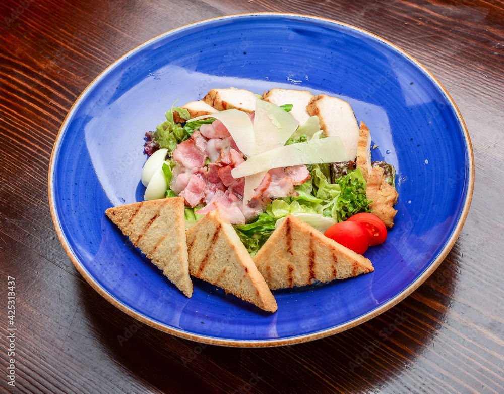 Chicken Caesar Salad. Caesar Salad with grilled chicken on plate. Grilled chicken breasts and fresh salad in plate