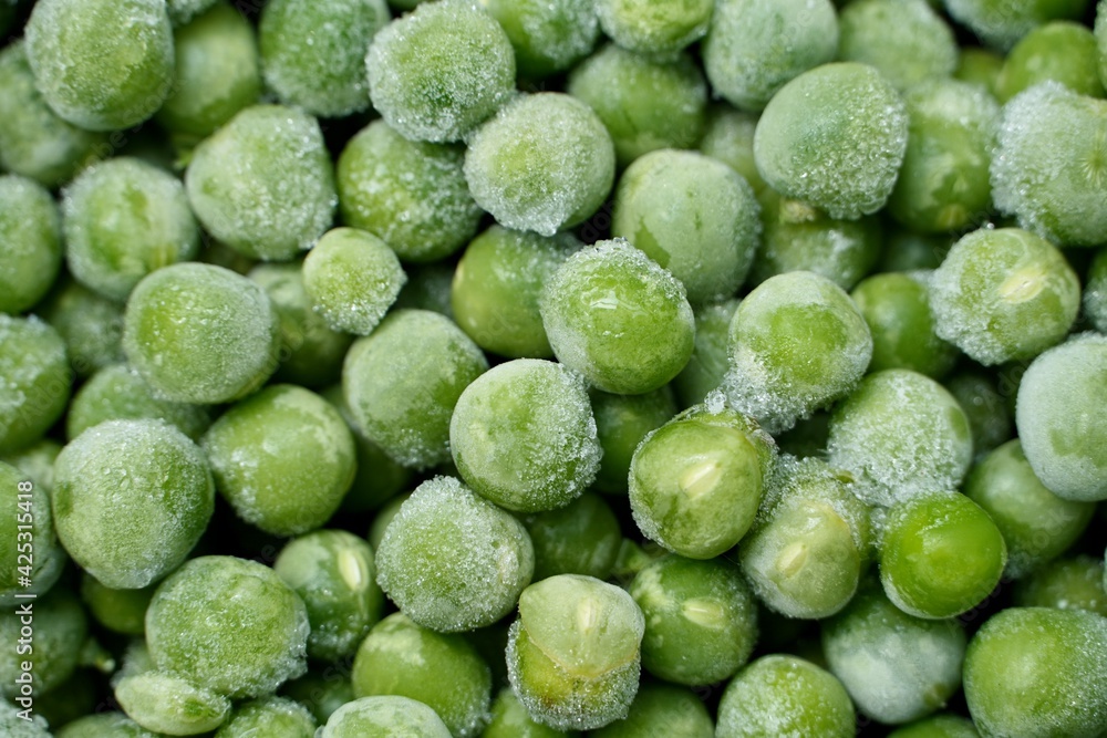 Green peas close up. Green peas texture. Healthy eating seeds of green vegetable pod. Full frame of frozen green peas kept for sale in market. Green peas close up. Green peas texture. Healthy eating seeds of green vegetable pod. Full frame of frozen green peas kept for sale in market.