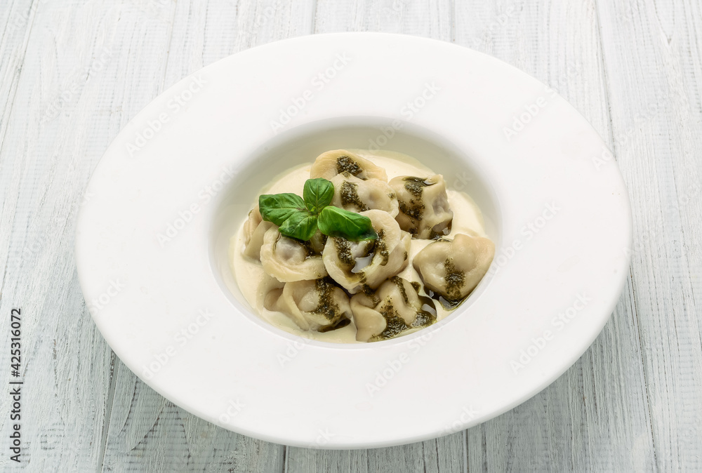 Meat dumplings, ravioli with meat with pesto sauce on plate Meat dumplings, ravioli with meat with pesto sauce on plate