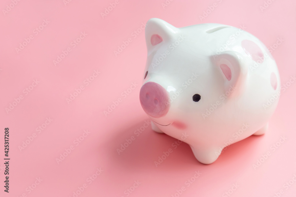 Ceramic piggy bank with copy space on pink background for saving concepts