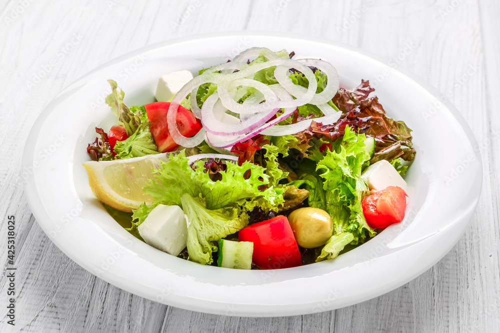 Fresh Greek salad in a bowl, top view