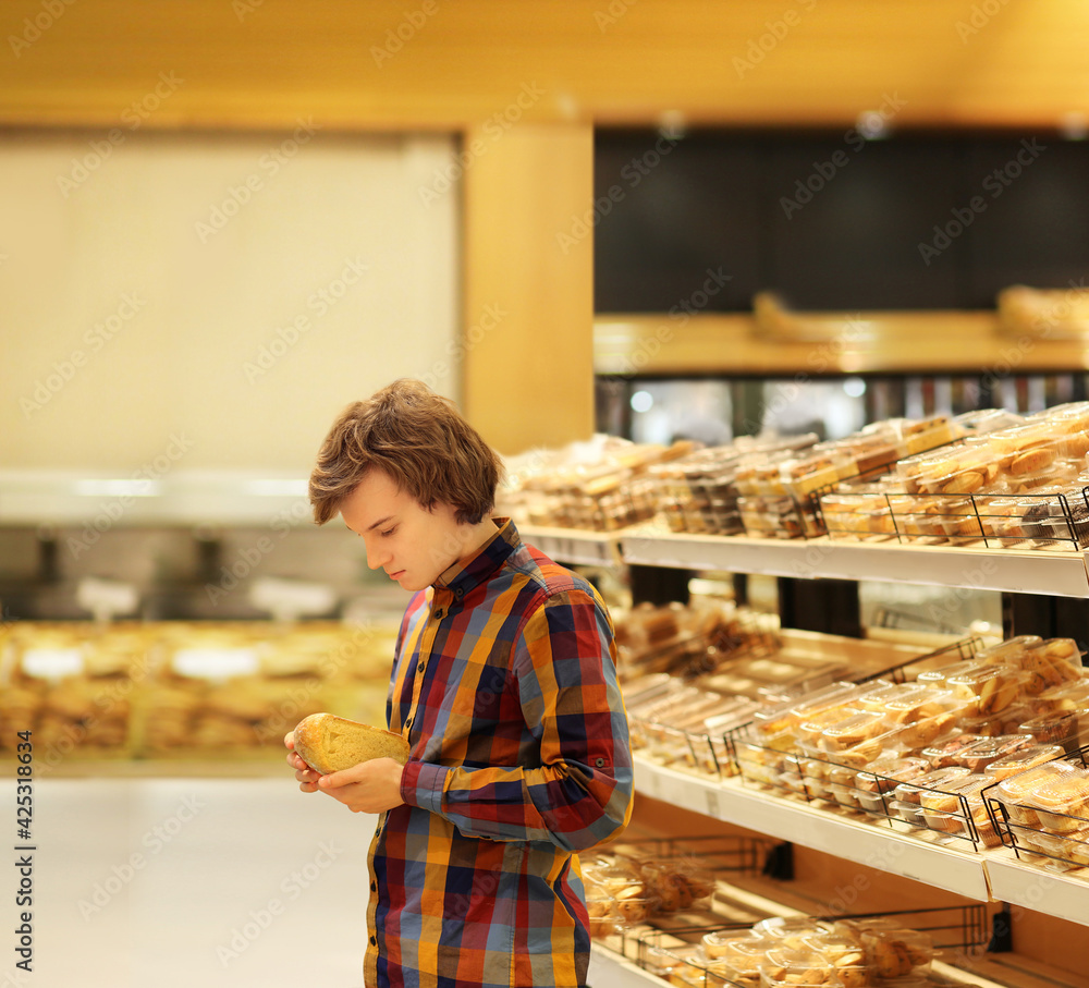 Teenager choosing bread from a supermarket.
