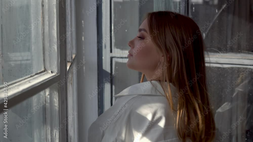 Relaxed model posing for a photo by the window Relaxed model posing for a photo by the window