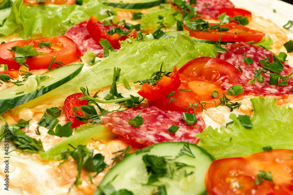 ingredients for shawarma are laid out on a thin pita bread. tomatoes, greens, salami, cheese, cucumber and lettuce close-up ingredients for shawarma are laid out on a thin pita bread. tomatoes, greens, salami, cheese, cucumber and lettuce close-up