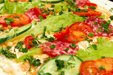 ingredients for shawarma are laid out on a thin pita bread. tomatoes, greens, salami, cheese, cucumber and lettuce close-up