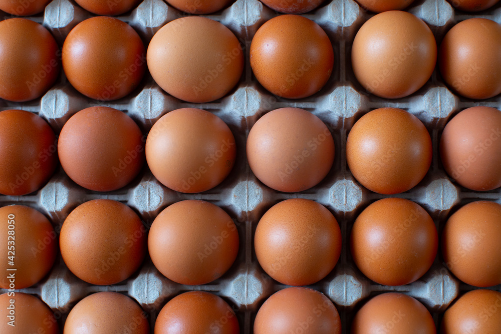 Rural, raw and fresh eggs in cartoon egg box tray, close-up with soft and select focus and isolated copy space. Rural, raw and fresh eggs in cartoon egg box tray, close-up with soft and select focus and isolated copy space.