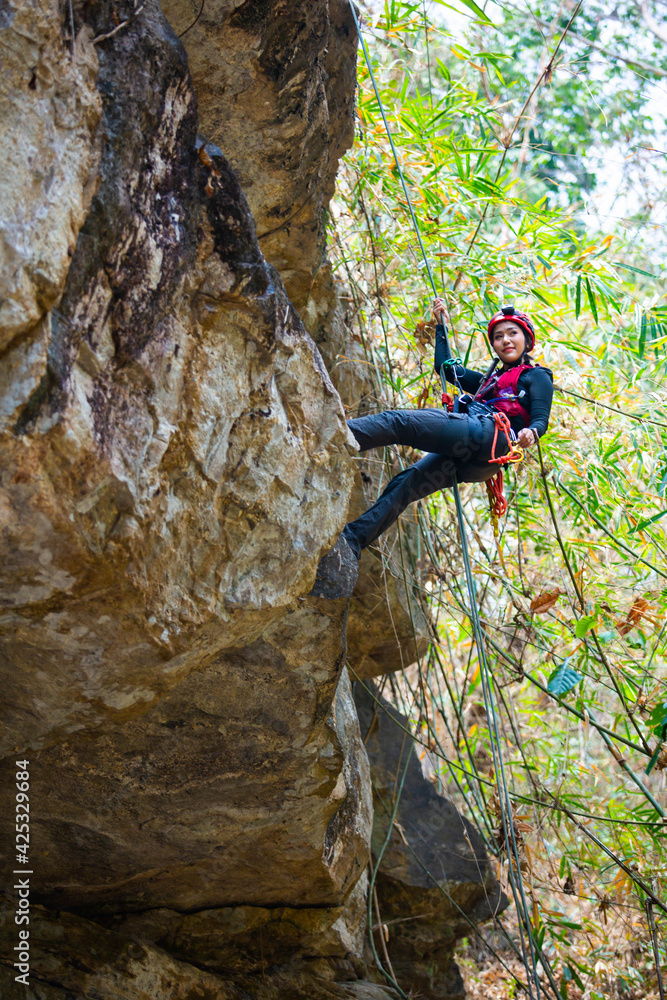 Beautiful young Asian climbers are climbing the high cliffs of northern Thailand.