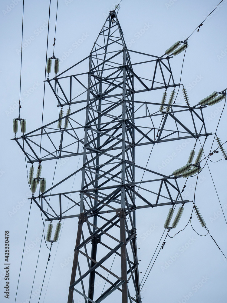 Power tower close-up against a gray sky in winter. Power transmission and communication technologies. horizontal photo Power tower close-up against a gray sky in winter. Power transmission and communication technologies. horizontal photo