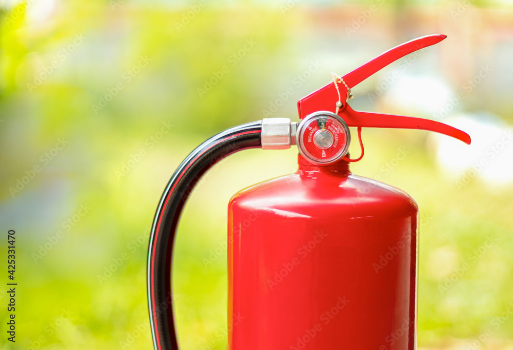 Obraz premium fire safety extinguishers, On a natural green blurred background.