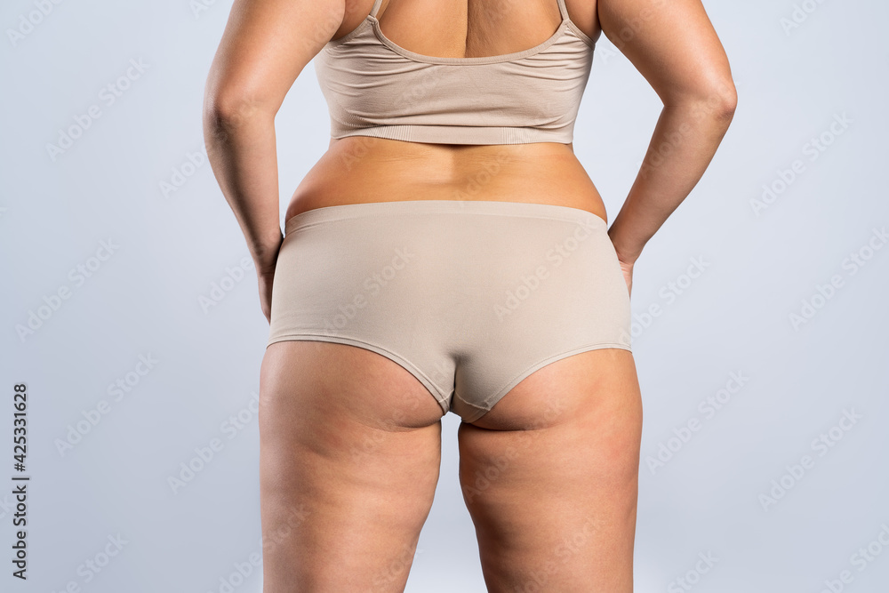 Overweight woman with fat hips and buttocks, obesity female body on gray  background Stock Photo