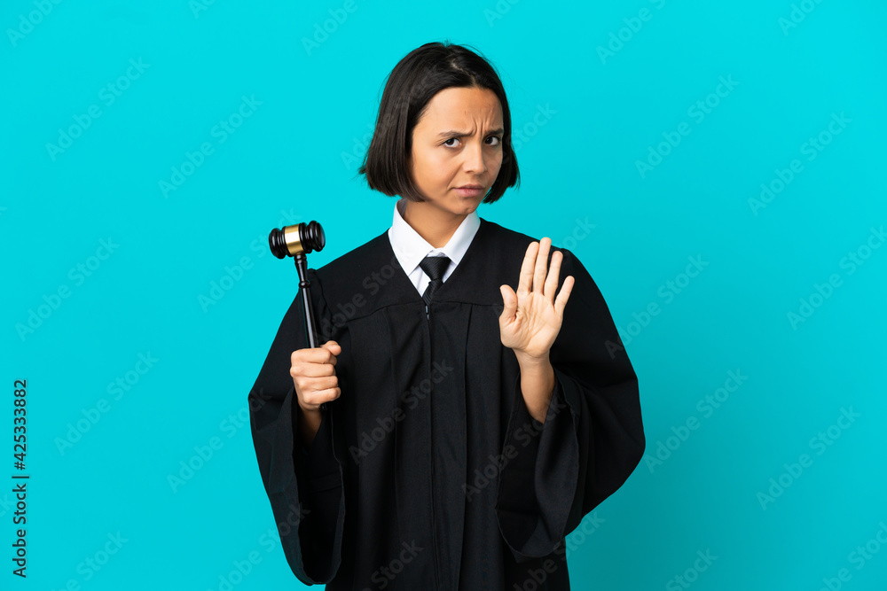 Judge over isolated blue background making stop gesture Judge over isolated blue background making stop gesture