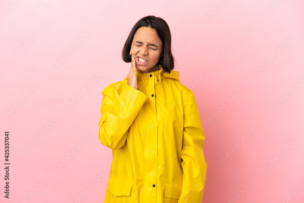 Young latin woman wearing a rainproof coat over isolated background with toothache Young latin woman wearing a rainproof coat over isolated background with toothache