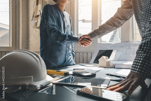 Architect shaking hands with clients to achieve agreement to work together at the office. photo