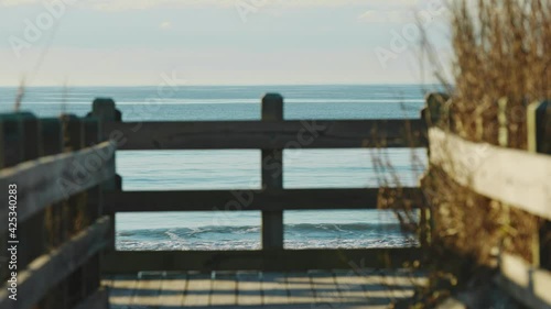 Wallpaper Mural Slow motion shot of waves from the ocean during beautiful sunny day. View from wooden walkway with barrier. Torontodigital.ca