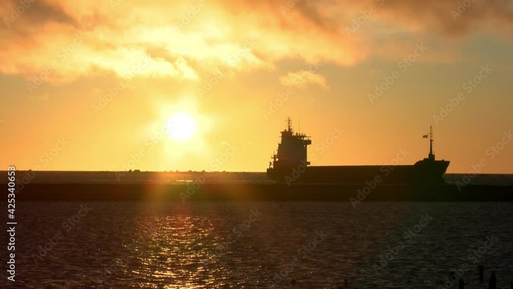 cargo ship was approaching shore at sunset cargo ship was approaching shore at sunset